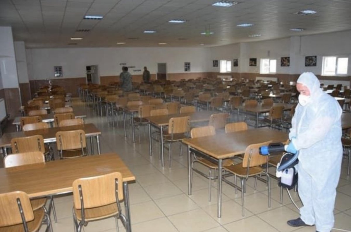 Askerler aralıklı düzende oturup, virüsten korunuyor