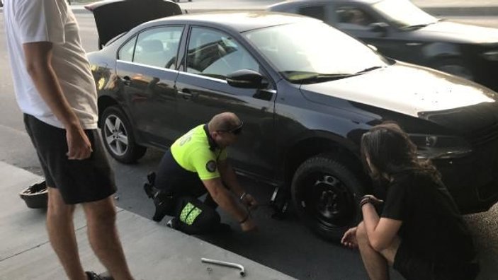 Trafik polisi, patlak lastikle giden gençlere yardım etti
