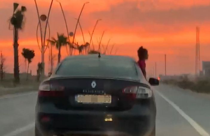 Seyir halindeki aracın camından sarkan çocuk korkuttu -1