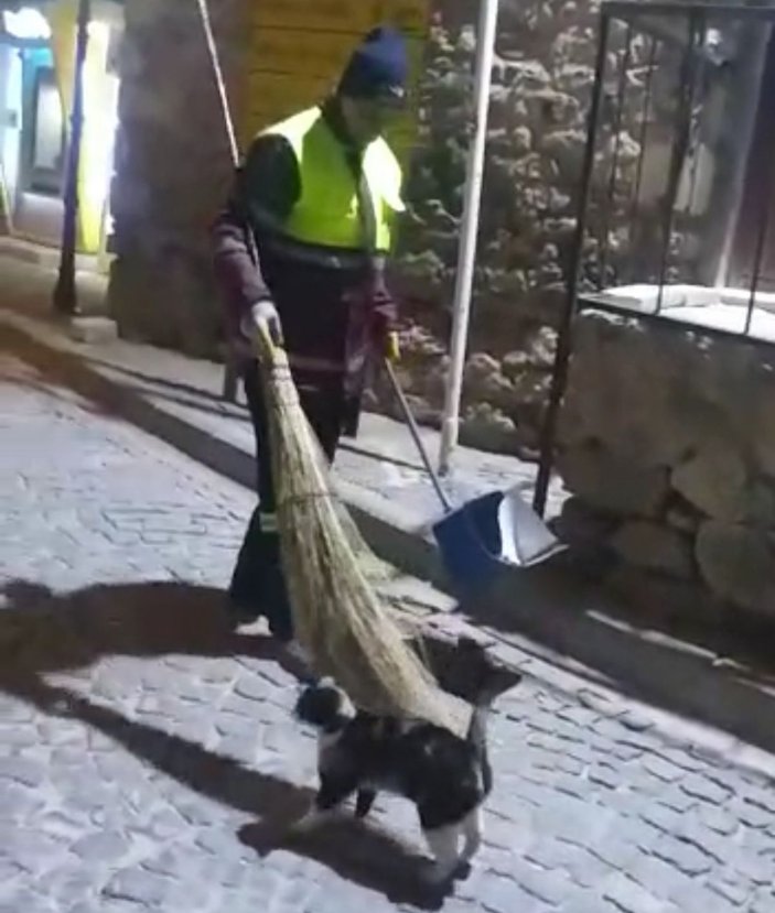 Hem çevreyi temizliyor hem de sokak kedisine süpürgesi ile masaj yapıyor -3