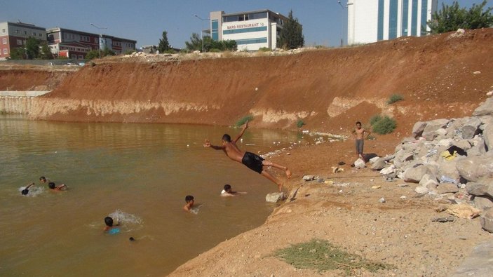 Çocuklar, inşaat temelini dolduran kirli suda yüzüyor -1