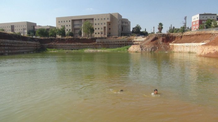 Çocuklar, inşaat temelini dolduran kirli suda yüzüyor -7
