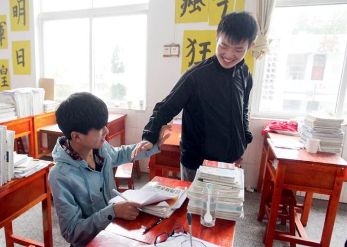 Çinli çocuk engelli arkadaşını her gün sırtında taşıyor