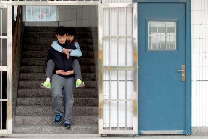 Çinli çocuk engelli arkadaşını her gün sırtında taşıyor