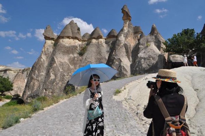 Kapadokya'da turistler şemsiye ile geziyor