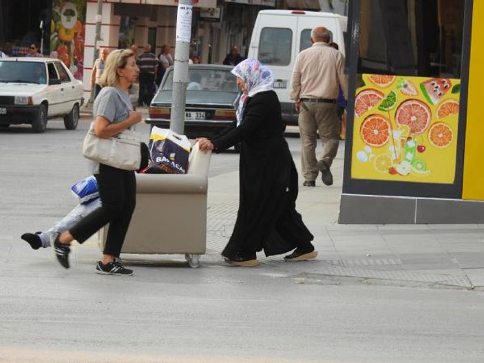 Engelli kızını sokakta koltukla gezdiriyor