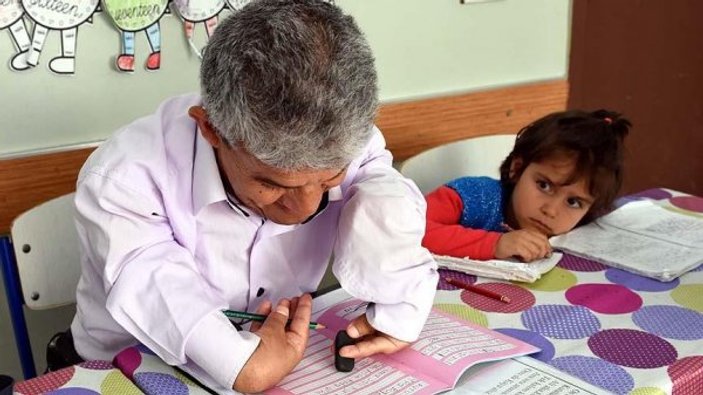 Kızının yardımıyla okuma yazma öğreniyor