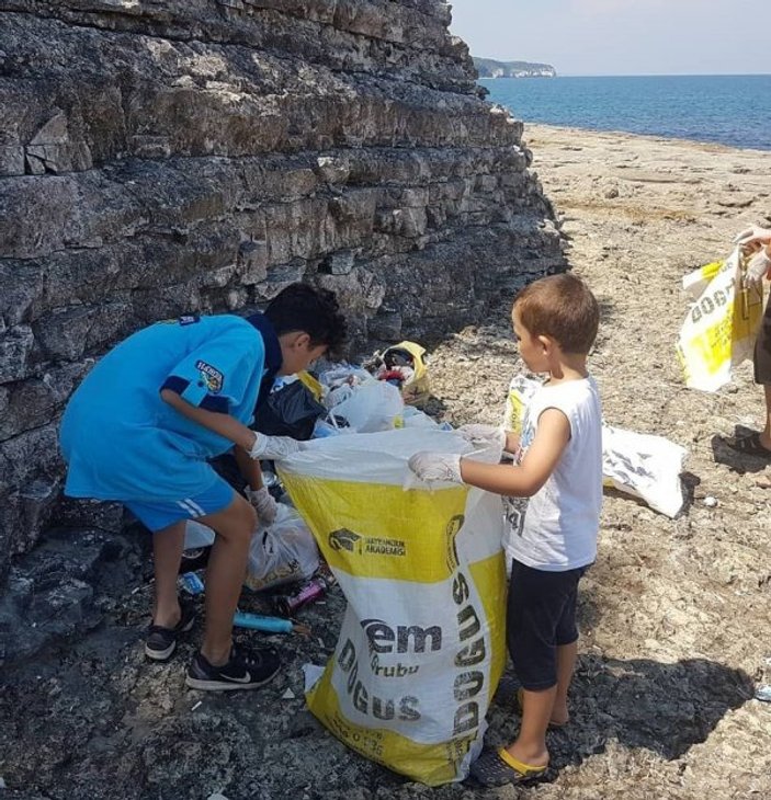 Çocuklarıyla tatilcilerin bıraktığı çöpleri topladı