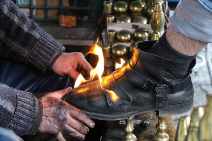 Amasyalı adam ayakkabıları ateşle boyuyor