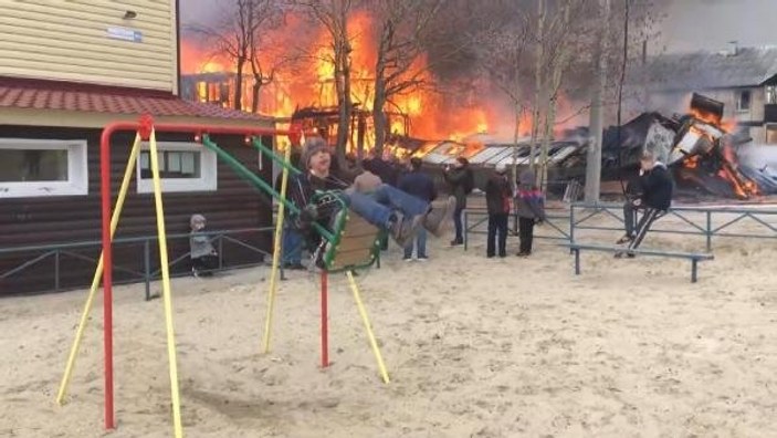 Arkasında ev yanarken eğlenen Rus çocuk