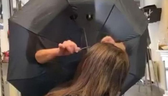 Şemsiyeyle önlem alarak müşterilerinin saçını kesti