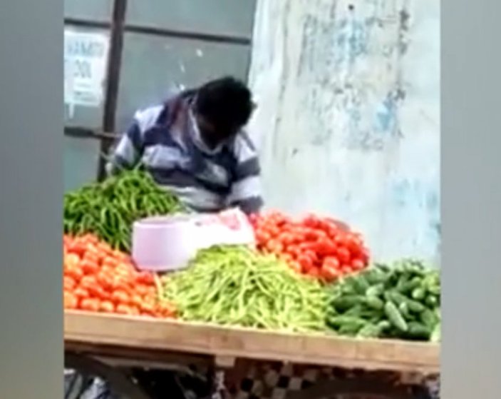 Hindistan'da sebzeleri göbeğiyle silen satıcı