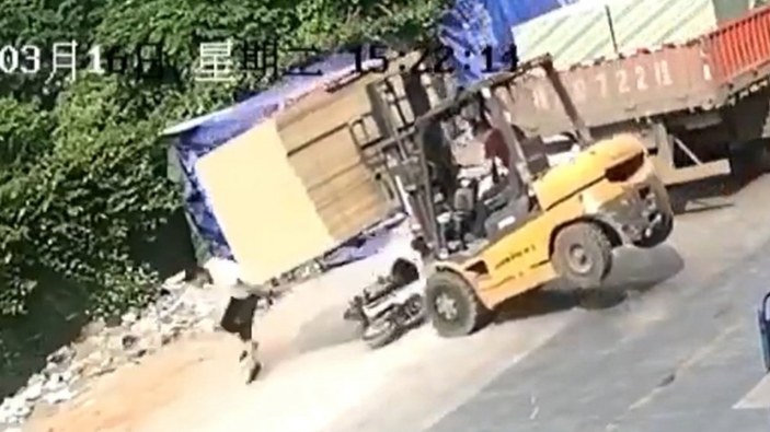 Çin'de motosiklet sürücüsü, tahtaların altında kalmaktan son anda kurtuldu
