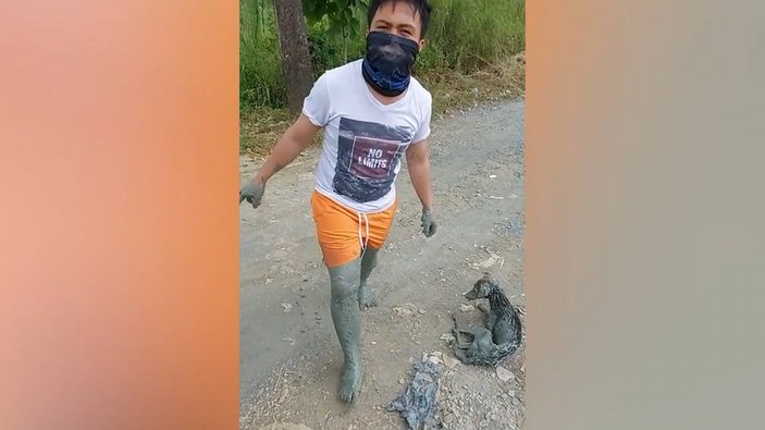 Filipinler'de köpeği kurtarmak için bataklığa giren adam