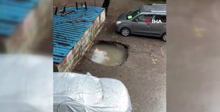 Hindistan’da park halindeki otomobil, su dolu çukura düştü