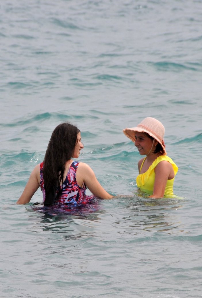 Antalya’da turistler, bulutlu havaya rağmen denize girdi