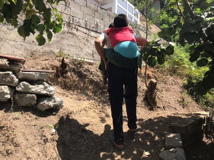 Zonguldak'ta engelli üvey oğlunu sırtında taşıyan baba