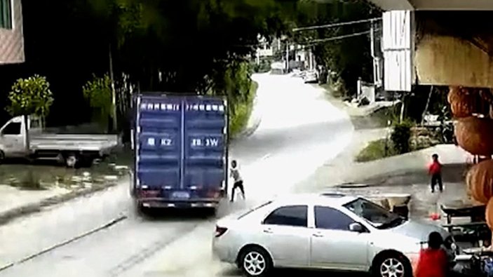 Çin’de, yola atlayan çocuk kamyonun altında kalmaktan saniyeler ile kurtuldu