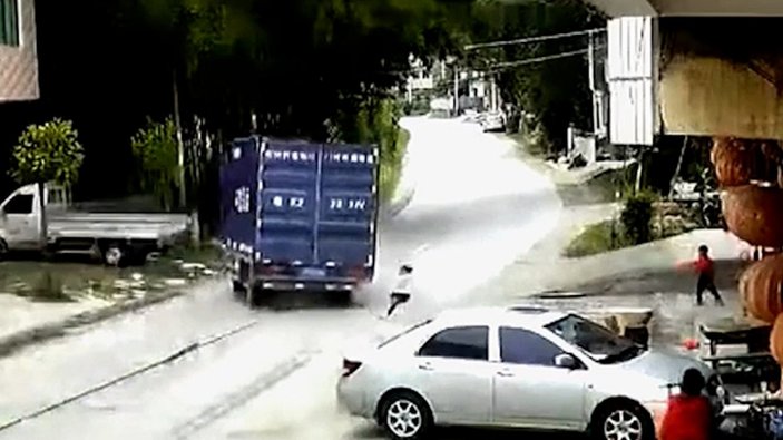 Çin’de, yola atlayan çocuk kamyonun altında kalmaktan saniyeler ile kurtuldu