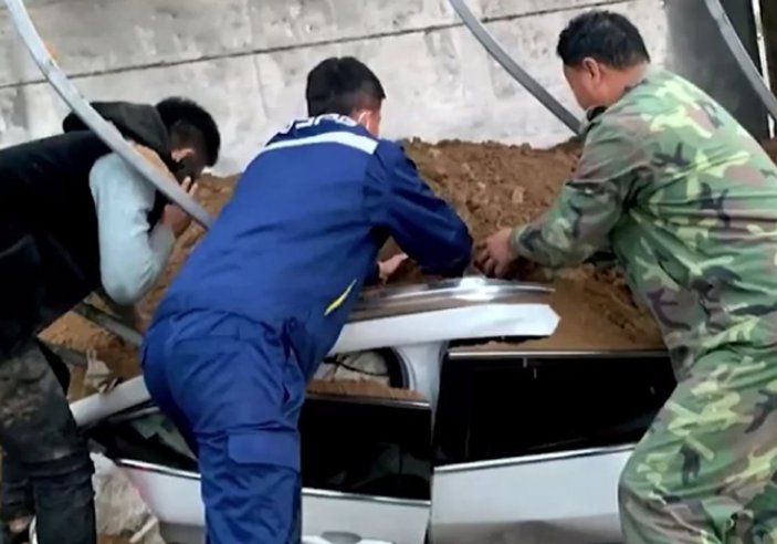 Çin'de kum taşıyan kamyon otomobilin üzerine devrildi