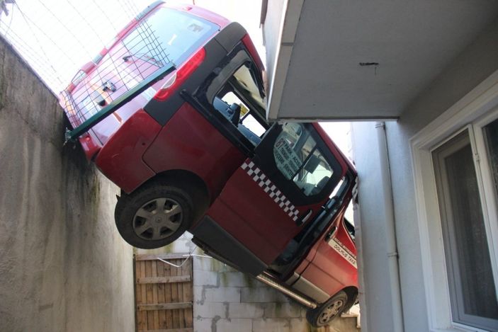 Kocaeli'de dolmuş taksi, apartman boşluğunda asılı kaldı