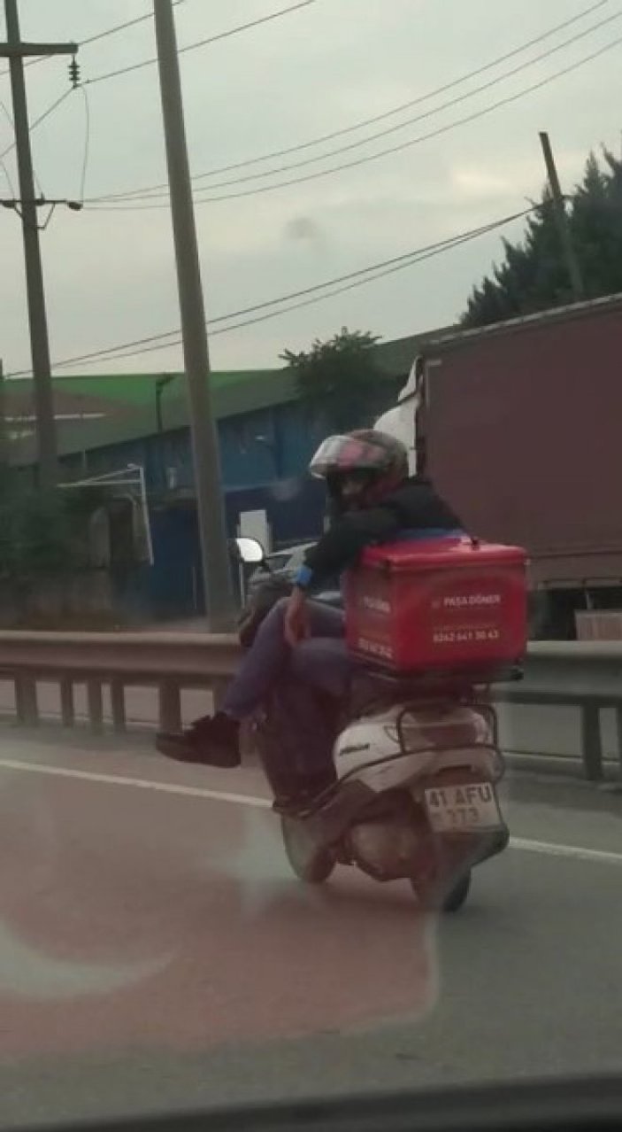 Tuzla’da motosikletli kurye trafikte, bacak bacak üstüne atarak ilerledi