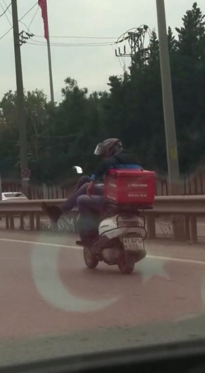 Tuzla’da motosikletli kurye trafikte, bacak bacak üstüne atarak ilerledi