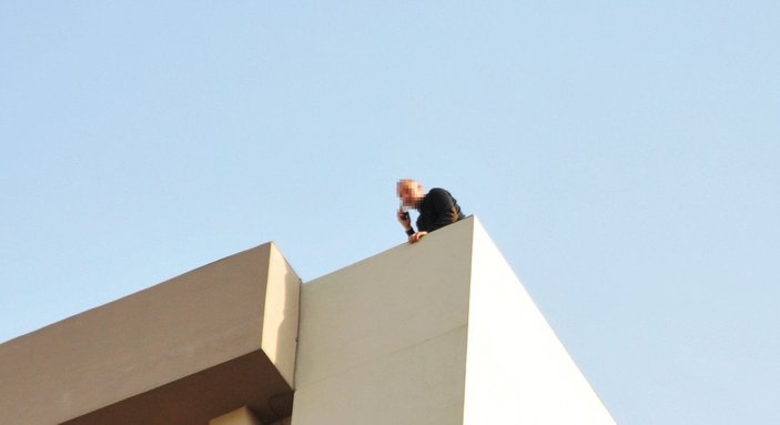 Antalya’da, boru anahtarıyla çatıya çıkıp eylem yaptı