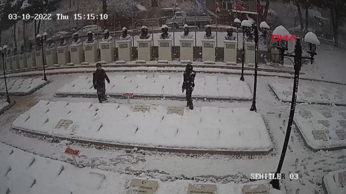 d Çanakkale'de 2 genç, beyaza bürünen şehitlikteki mezar taşlarını temizledi