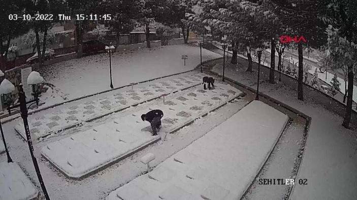 d Çanakkale'de 2 genç, beyaza bürünen şehitlikteki mezar taşlarını temizledi