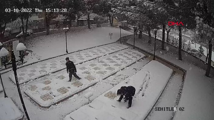 d Çanakkale'de 2 genç, beyaza bürünen şehitlikteki mezar taşlarını temizledi