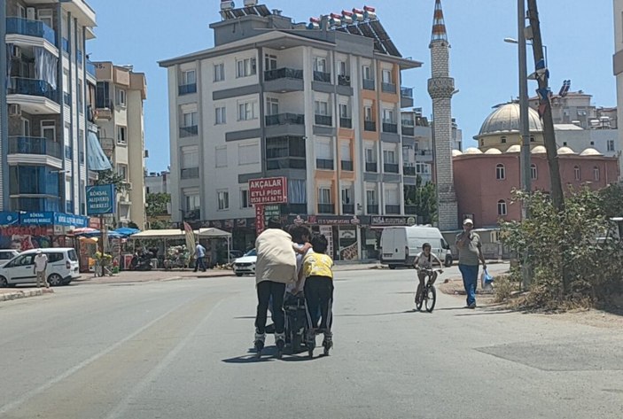 Antalya'da elektrikli bisiklete tutunarak yolculuk yapan patenli çocuklar