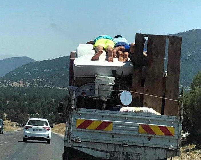 Muğla'da eşya yüklü kamyonetin kasasındaki yatakta tehlikeli yolculuk