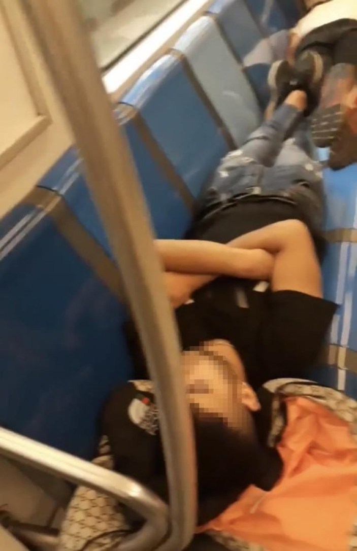 Metroda koltuklara uzanarak uyuyan bir grup genç kamerada