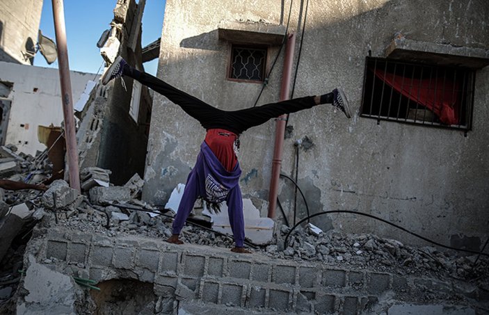 Gazze'de gençlerin İsrail saldırılarında yıkılan evlerin enkazındaki parkur sporu