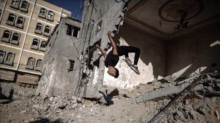 Gazze'de gençlerin İsrail saldırılarında yıkılan evlerin enkazındaki parkur sporu
