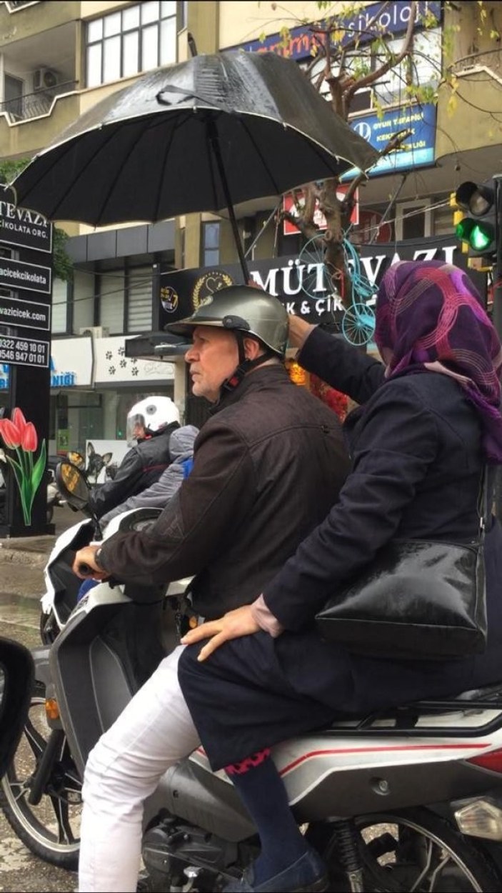 Adana'da sağanak yağışta kocasına şemsiye tuttu