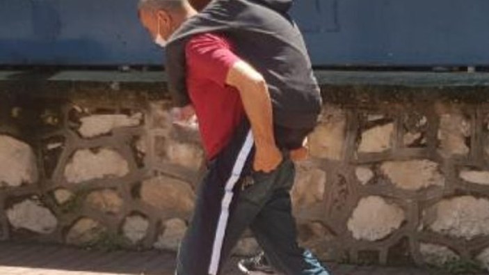 Bursa'da ayağı alçılı oğlunu okula sırtında taşıdı