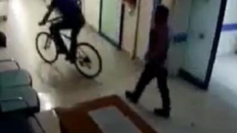 Hastane koridorunda bisiklet süren doktor