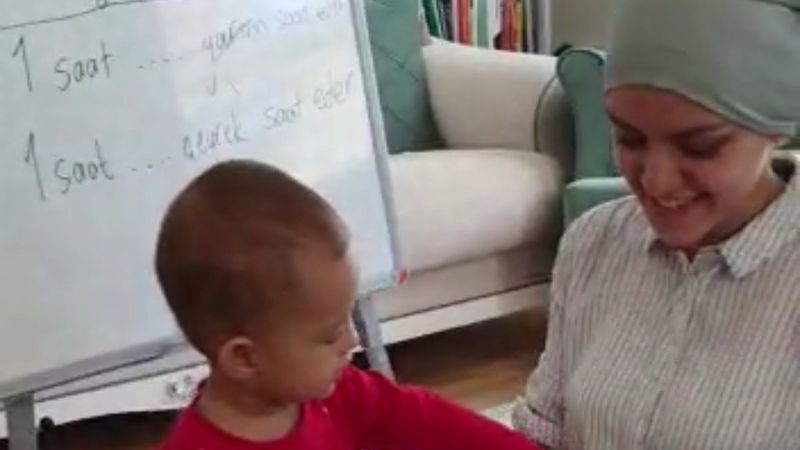 Öğrencilere ders anlatırken çocuğuyla da ilgilenen öğretmen