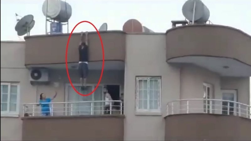 Mersin'de binanın çatısından sarkan kişi yürekleri ağza getirdi