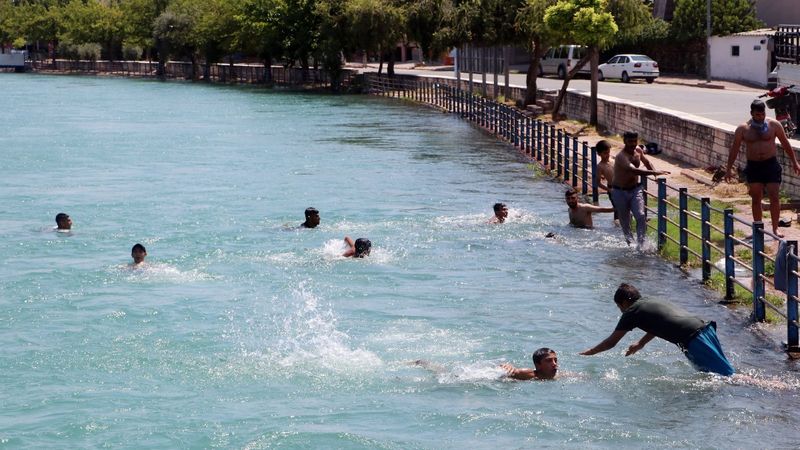 Adana'daki çocuklar, sulama kanalında serinlemeye çalışıyor