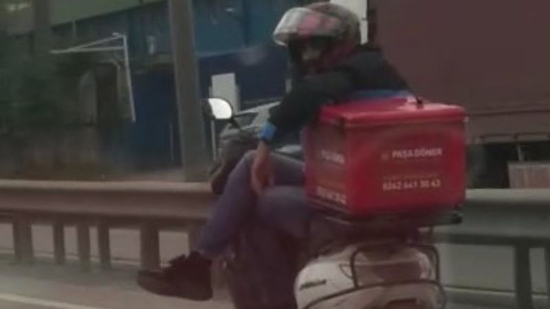 Tuzla’da motosikletli kurye trafikte, bacak bacak üstüne atarak ilerledi