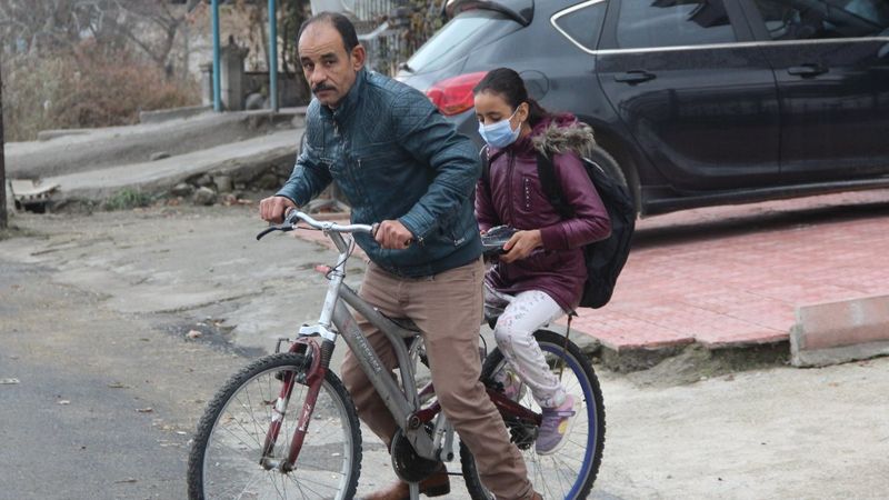 Malatya'daki baba, yürüyemeyen kızını bisikletle okula taşıyor