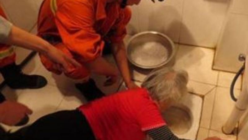 Çinli yaşlı kadının kolu tuvalate sıkıştı