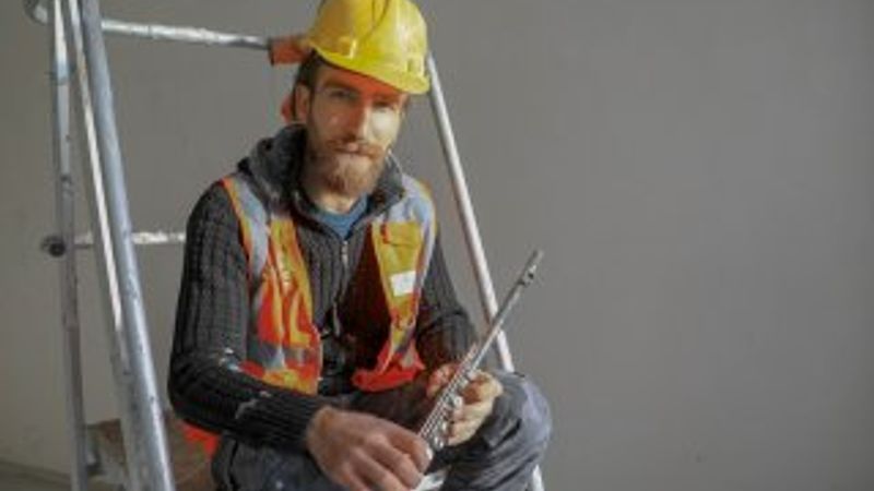 Yan flüt çalan inşaat işçisi