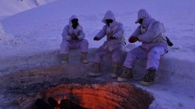 Kar üzerinde ateş yakan Mehmetçik