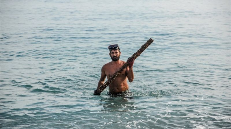 Akdeniz'e tüpsüz dalarak metal atık topluyor