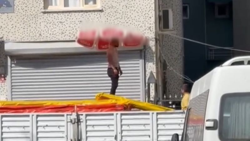 Şırnak'ta kavurucu sıcaktan beline bağladığı plaj şemsiyesiyle korunmaya çalıştı