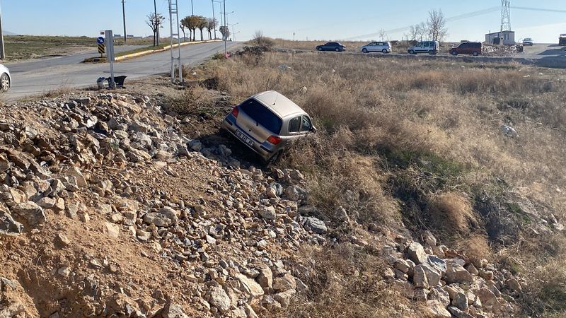 Çorum'da yoldan çıkan otomobil, taşlık alanda asılı kaldı